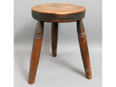 An early 20thC. oak milking stool, dated 1914, 16.