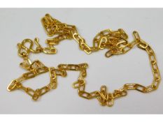 A yellow metal chain, indistinctly marked, tests e