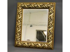 A decorative framed mirror with leaf & berry desig