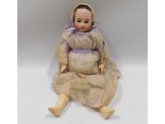 A porcelain headed doll, 16in tall
