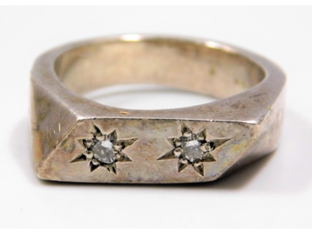 A silver ring set with two small diamonds of appro
