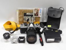 A Nikon FM 35mm film camera with 28-70mm lens & ma