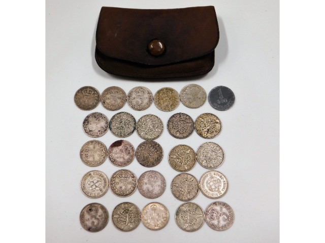 A small purse with a selection of threepence coina