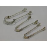 A pair of ornate, white metal tongs with Victorian