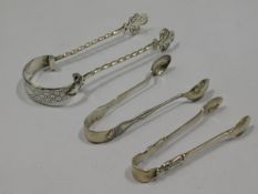 A pair of ornate, white metal tongs with Victorian