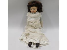 A porcelain headed doll, 14in tall