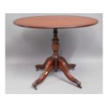 A mahogany occasional table with brass claw feet &