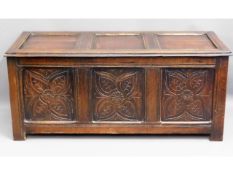 An antique oak coffer with carved panel design, 51