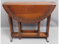 An oak gate leg table with carved decor to top, 36