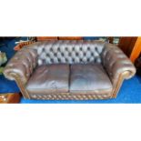 A brown leather Chesterfield style two seater club