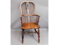 A 19thC. elm Windsor chair, fault to edge of seat