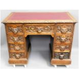 An antique carved 'green man' oak desk, one drawer