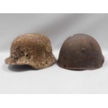 Two trench find helmets, one a German WW2, the oth