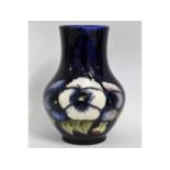 A Moorcroft vase decorated with pansies, green sig