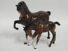 A Beswick mare, foot raised & foal, head down, tal