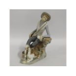A Lladro figure of boy with dog, 7.25in tall