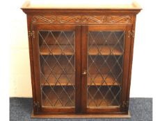 An oak wall mountable glazed book case, 31.75in wi