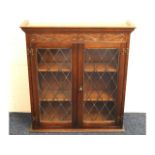 An oak wall mountable glazed book case, 31.75in wi