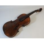 An antique violin with carved lions head scroll & two piece back, lacking chin rest, tailpiece, tune