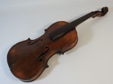 An antique violin with carved lions head scroll & two piece back, lacking chin rest, tailpiece, tune