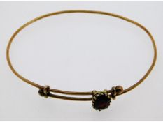 A ladies 9ct gold sliding bangle set with garnet, 5g