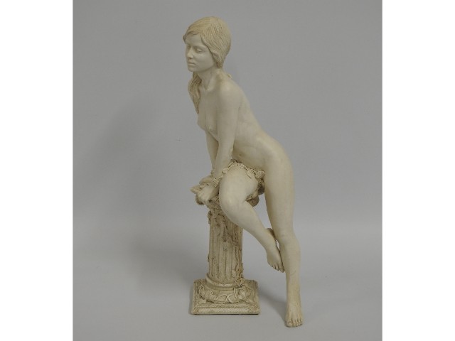 A 20thC. resin statue of girl leaning on a pedesta