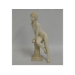 A 20thC. resin statue of girl leaning on a pedesta