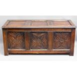 An antique oak coffer with carved panel design, 51