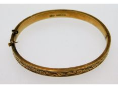 A 9ct gold bangle with carved decor, lacks safety