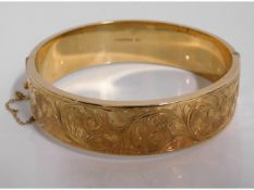 A 9ct gold bangle with chased decor, 33.6g