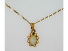 A 14ct gold pendant set with opal, 15mm drop, on a