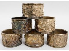 A set of six silver plated napkin rings with relie