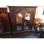 A large mahogany wardrobe with mirrored doors, 86i