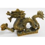 A detailed, antique brass Chinese dragon holding a