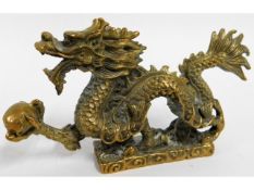 A detailed, antique brass Chinese dragon holding a
