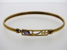 A 9ct gold bangle set with amethyst, 64mm diameter