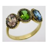 A 14ct gold ring set with diamond, topaz & peridot