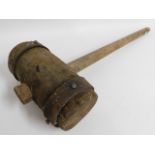 A large antique wooden mallet with iron strapping,