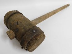 A large antique wooden mallet with iron strapping,