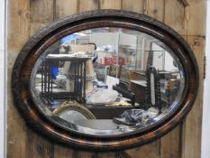 An oval mirror with oak leaf decorated frame, 34in