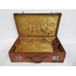 An antique leather suitcase with decorative lining