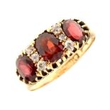 George V 18ct gold three stone garnet ring,