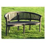 Two-seater teak garden bench of curved form