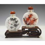 Two Chinese interior painted glass snuff bottles on stand