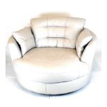Modern swivel circular snuggle sofa, upholstered in cream leatherette