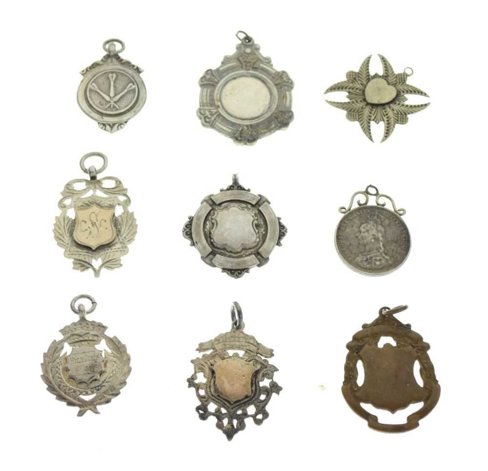 Six silver and white metal fobs