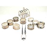 Group of assorted silver napkin rings, a pair of Georgian sugar tongs and a George VI toast rack