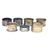 Three Edward VII silver napkin rings, together with four mixed napkins (7)