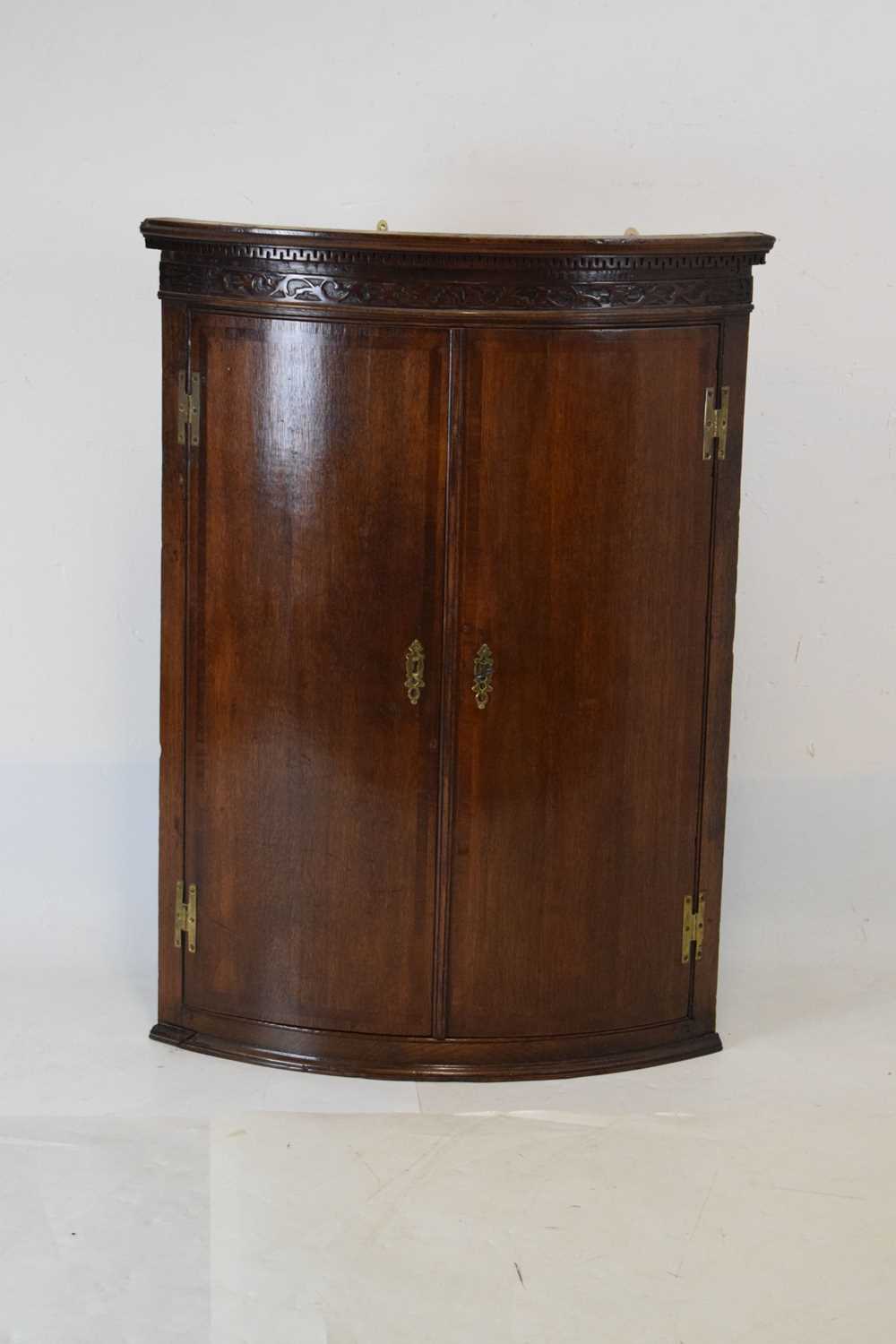 George III oak and mahogany bowfront corner cupboard