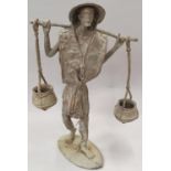 A cast metal figurine of a water carrier approx 34cm tall.
